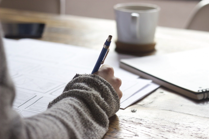 Title: Hand writing short notes on paper beside a cup of coffee - Description: Hand writing short notes on paper beside a cup of coffee