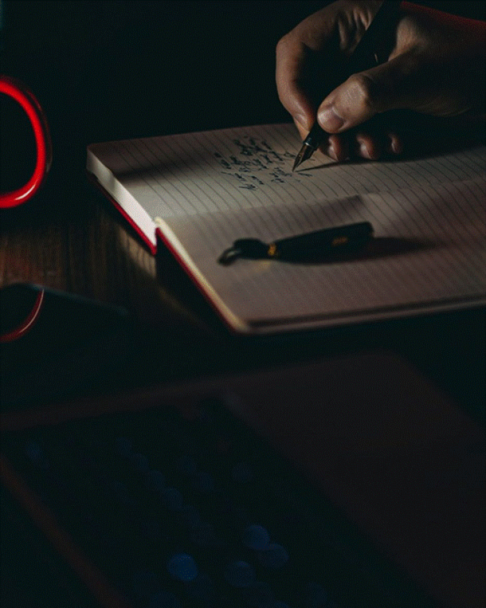 Title: A person writing a list on white paper - Description: A person writing a list on white paper