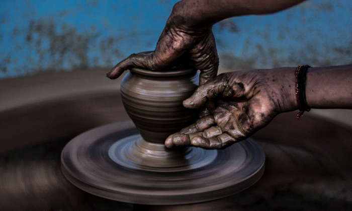 Title: Hands shaping a clay pot on a pottery wheel - Description: Hands shaping a clay pot on a pottery wheel