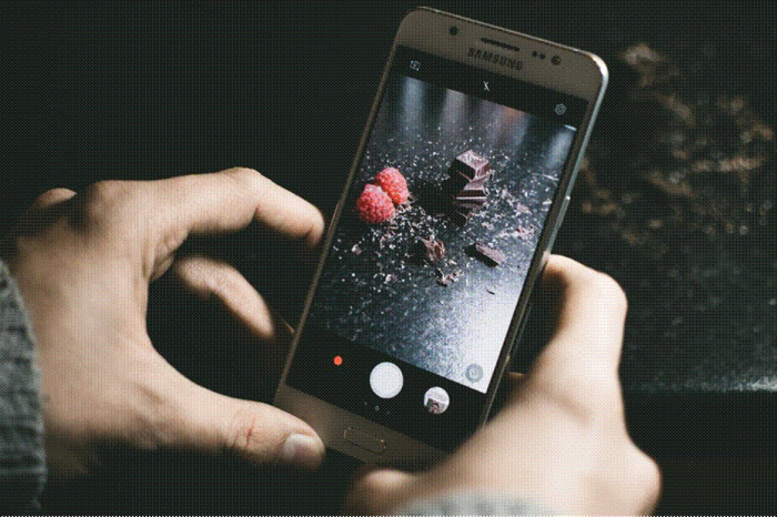 Title: Hand photographing a bowl of food with a smartphone - Description: Hand photographing a bowl of food with a smartphone