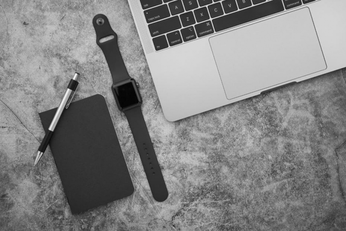 Title: Overhead view of a desk with laptop, notebook, coffee, and phone - Description: Overhead view of a desk with laptop, notebook, coffee, and phone
