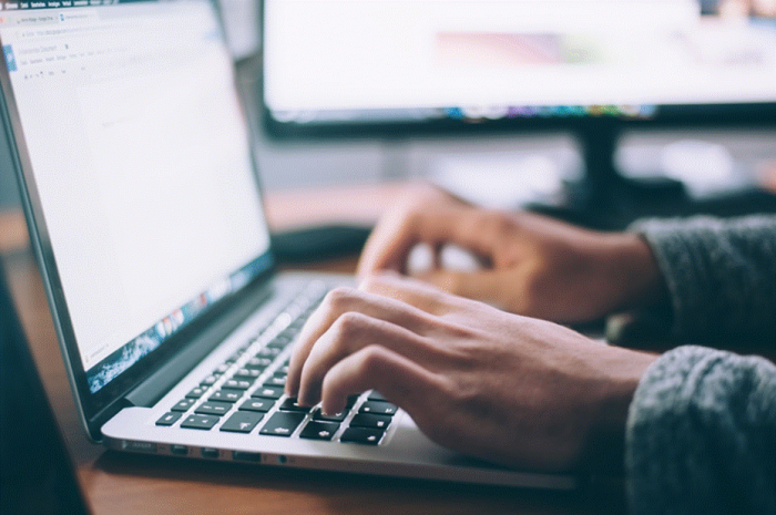 Title: Hands typing a search query on a laptop keyboard - Description: Hands typing a search query on a laptop keyboard
