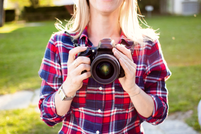 Title: Wedding photographer holding a camera outdoors - Description: Wedding photographer holding a camera outdoors